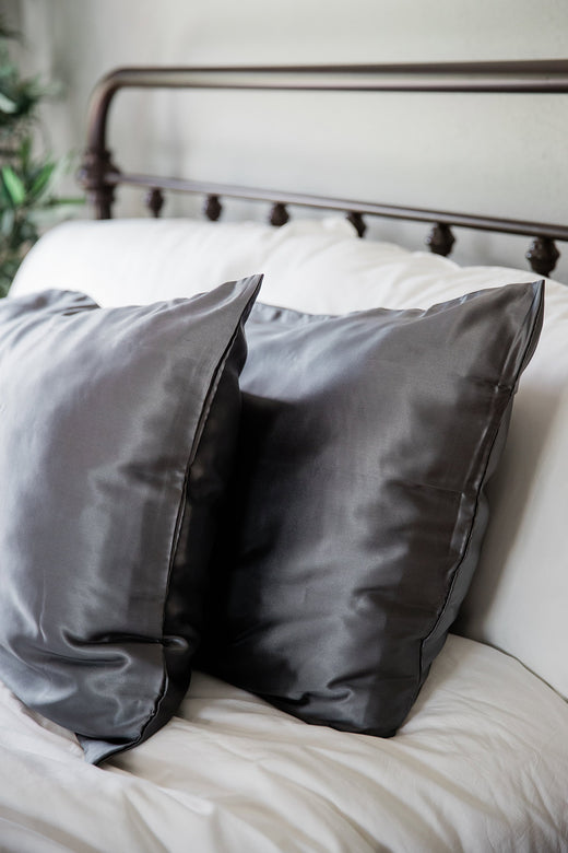 A pair of pillows enshrouded in Yala Charmeuse Pillowcase Set in Pewter
